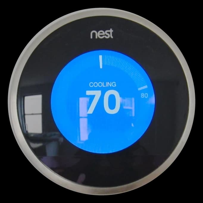 Nest Learning Thermostat on a wall, showing Cooling 70