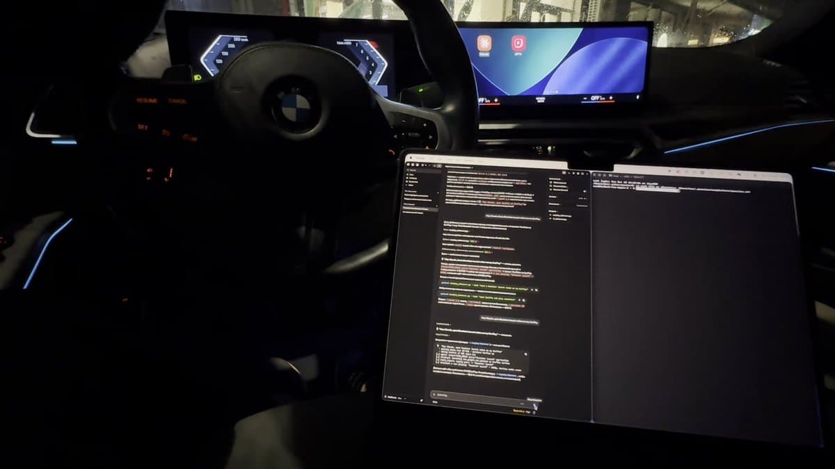 Source-post photo of a BMW cockpit and laptop; head-unit platform unverified